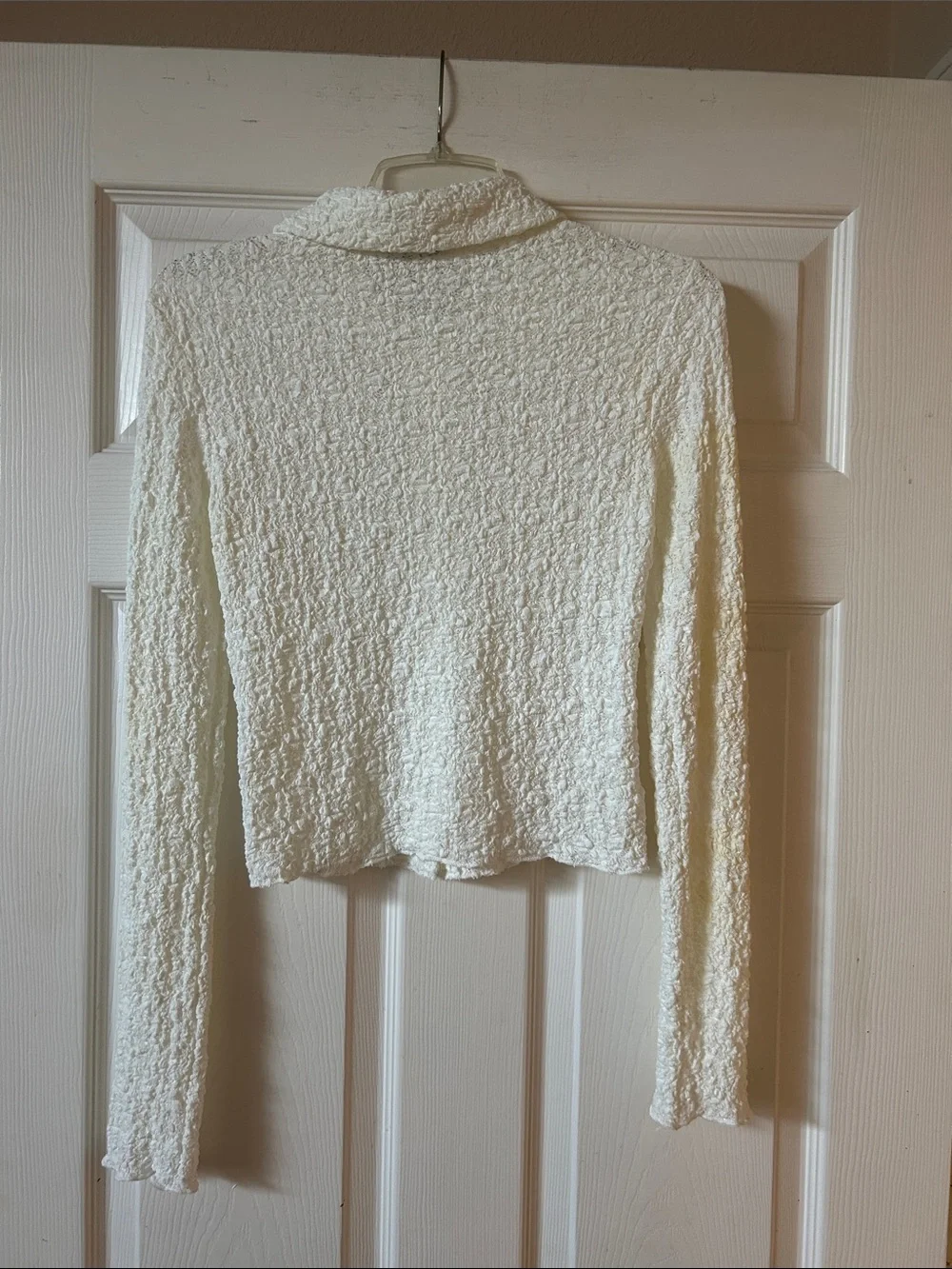 Shaped and cropped textured snap button front long sleeved collared shirt.